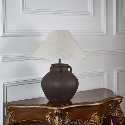 Brown ceramic table lamp with beige linen shade unlit on white background styled for home interior decor table lamp.