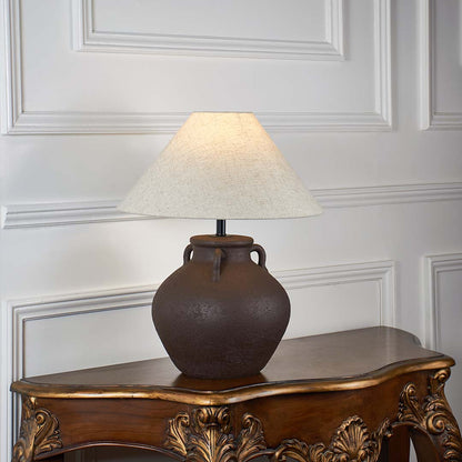 Brown ceramic table lamp with beige linen shade glowing on white background ideal for bedroom lighting table lamp.
