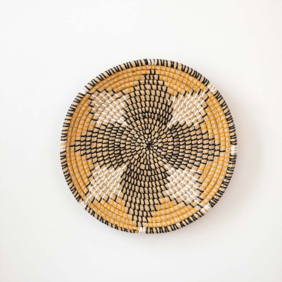 Amber black and natural woven decorative wall basket with floral pattern for elegant wall styling and home decor.