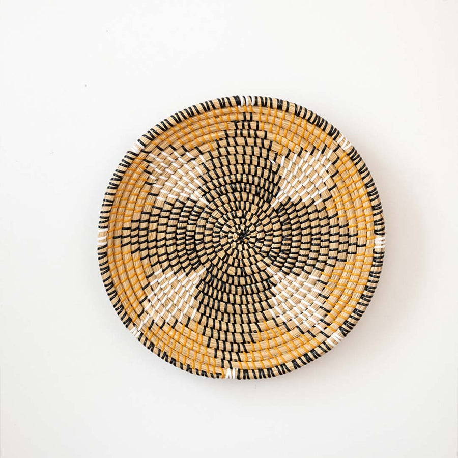 Amber black and natural woven decorative wall basket with floral pattern for elegant wall styling and home decor.