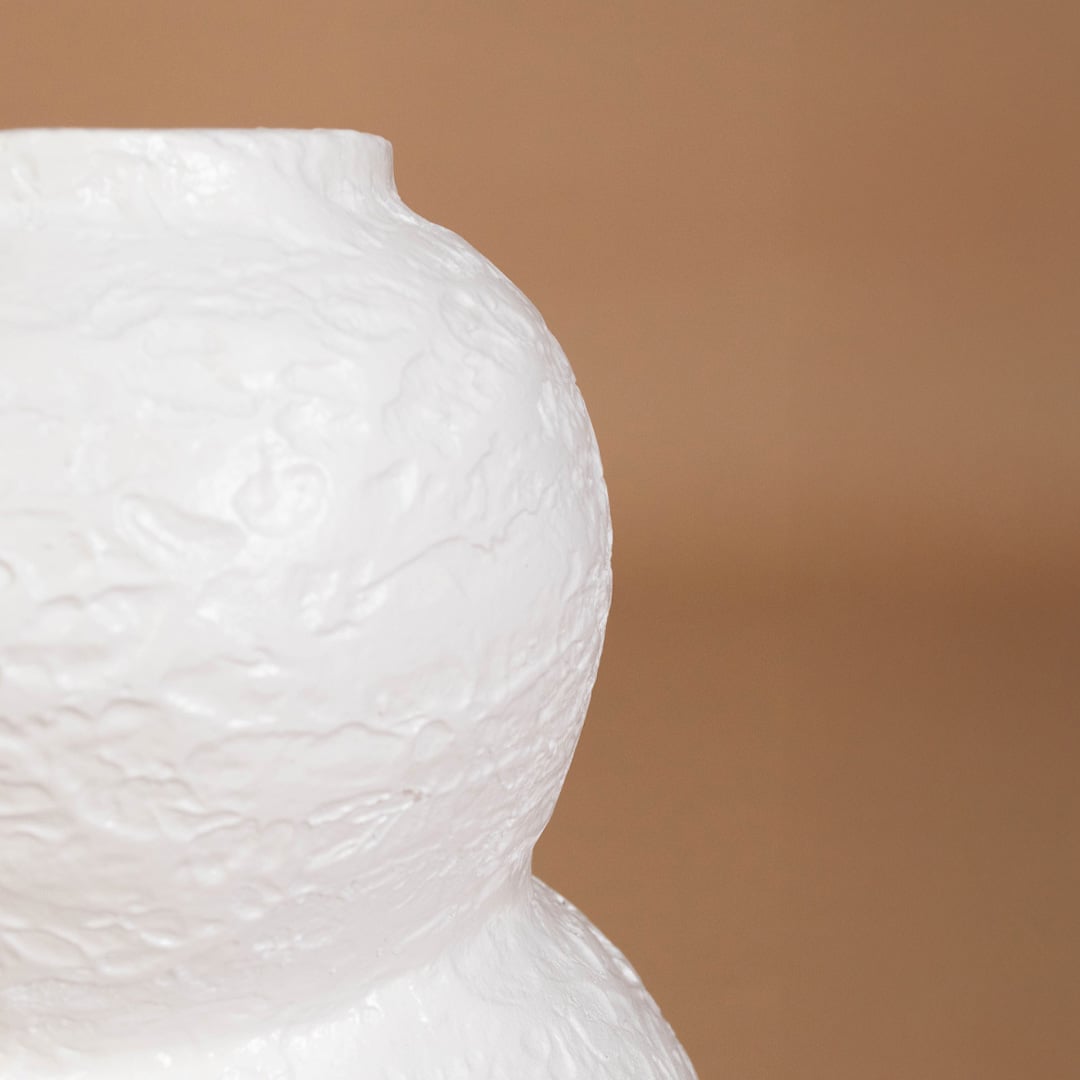 Closeup of white textured decorative vase showing detailed handmade surface and sculpted form ideal for artistic modern home interior decor.