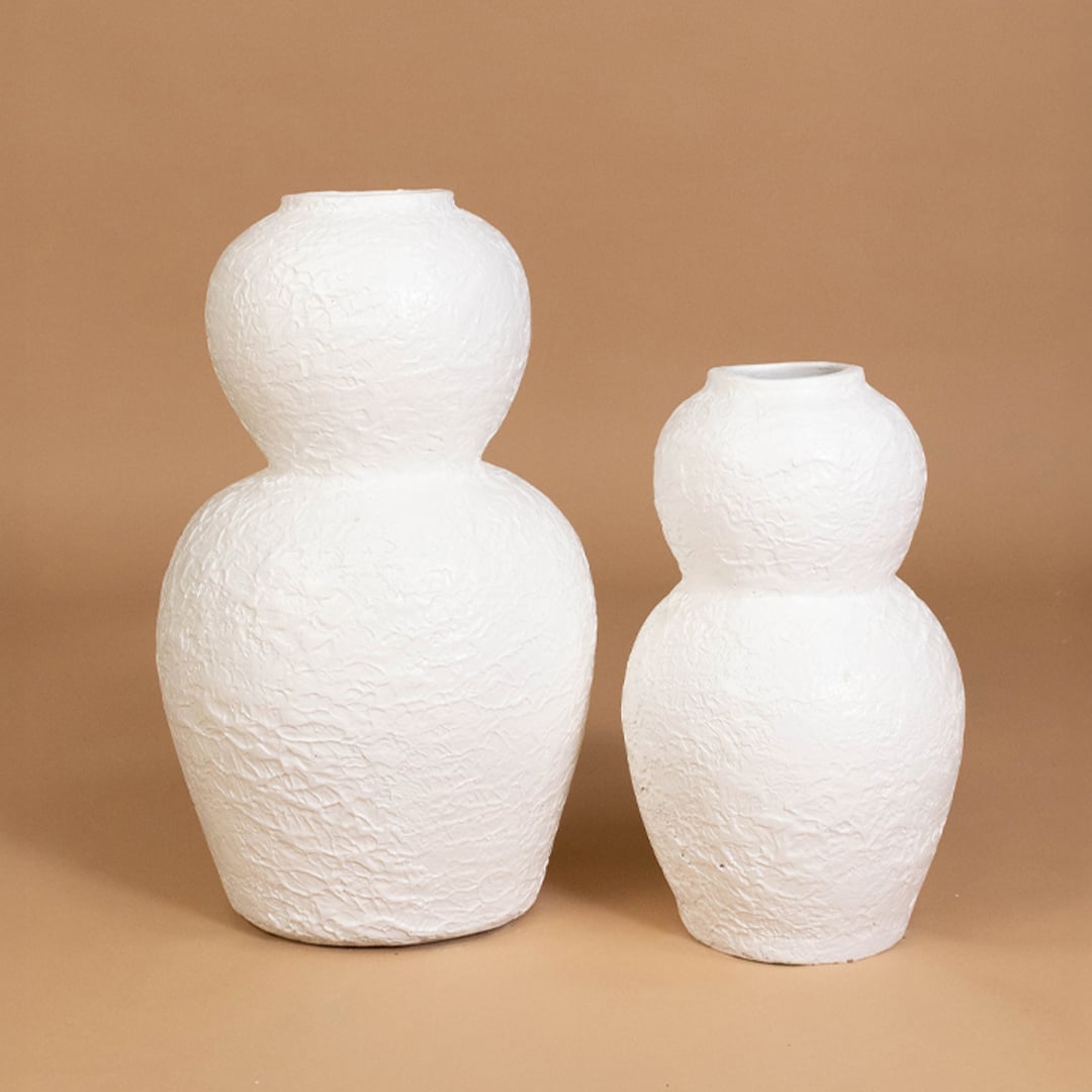 White textured decorative vase displayed with coordinated decor pieces creating a stylish grouped arrangement for contemporary interiors.