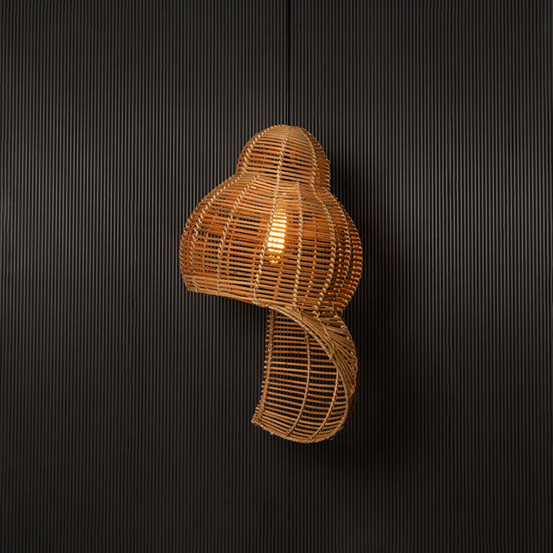 Double gourd rattan pendant light with handwoven bamboo frame turned on glowing softly against black background.