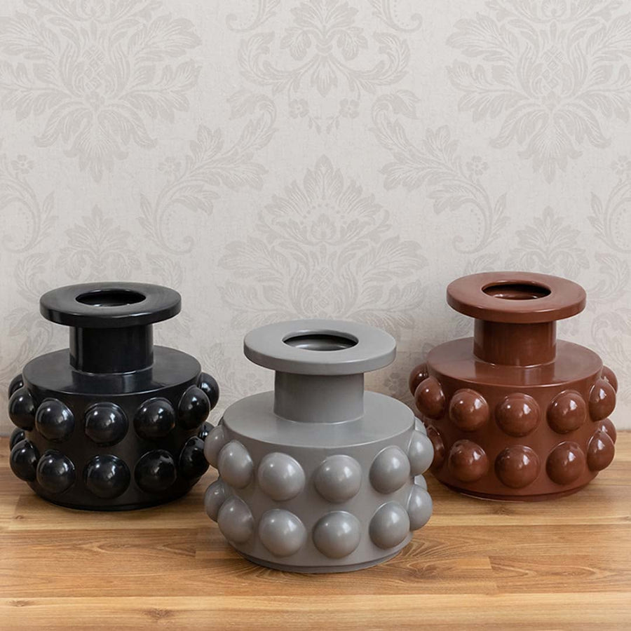 A grey textured decor vase shown in a styled setup highlighting its bold rounded details and contemporary shape perfect for modern home styling.