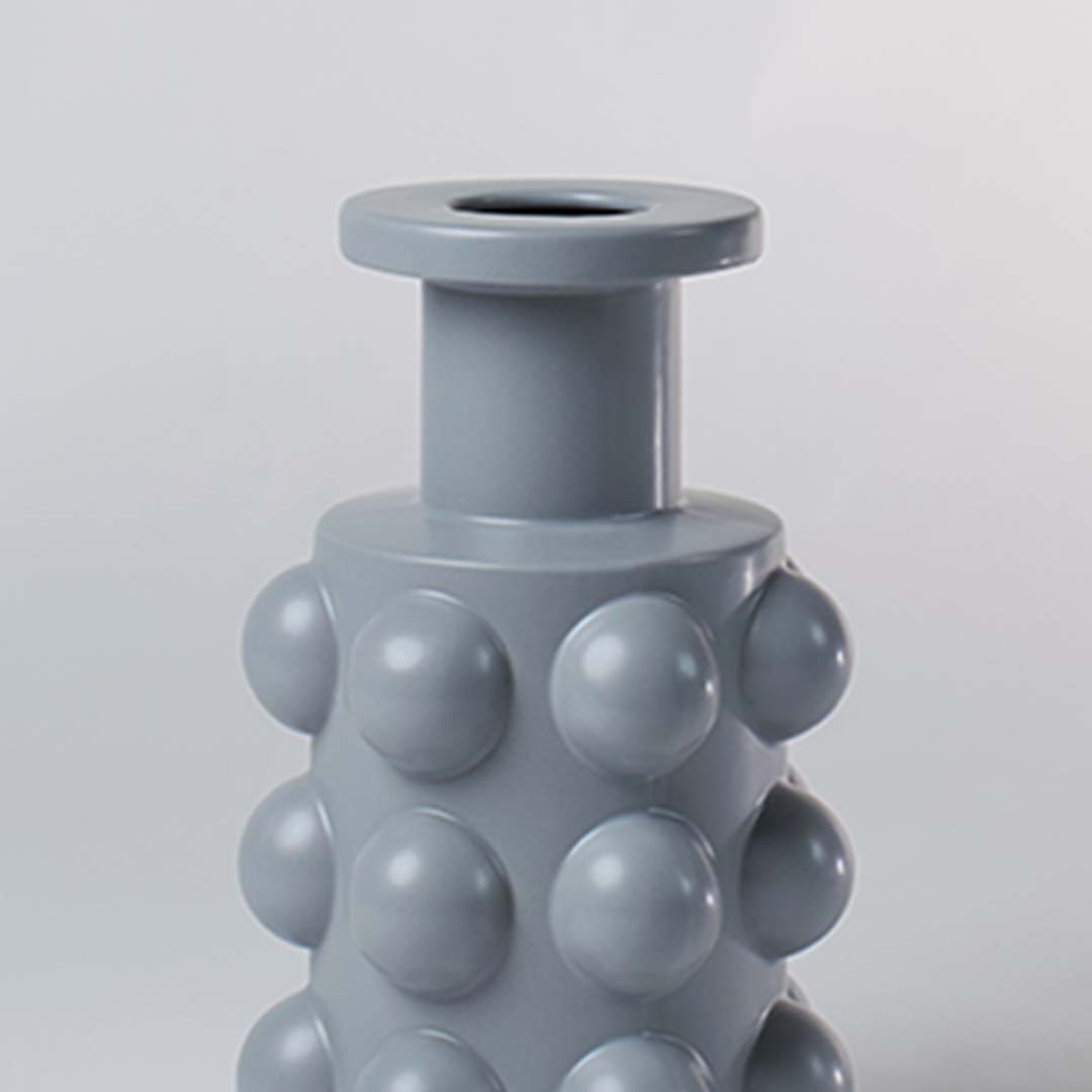 A detailed view of the grey sculptural vase showing its bold raised circular pattern and smooth finish highlighting its unique contemporary form.