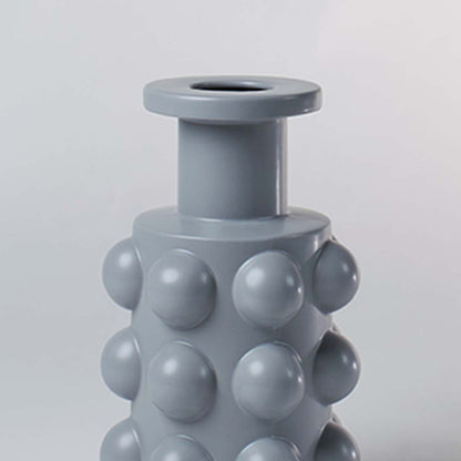 A detailed view of the grey sculptural vase showing its bold raised circular pattern and smooth finish highlighting its unique contemporary form.