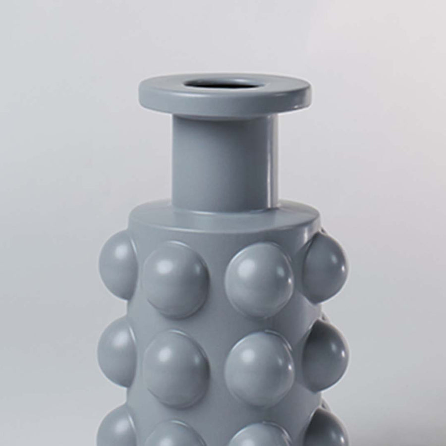 A detailed view of the grey sculptural vase showing its bold raised circular pattern and smooth finish highlighting its unique contemporary form.