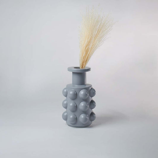 A textured grey decor vase with rounded raised elements shown in a simple styled space highlighting its modern artistic design for home styling.
