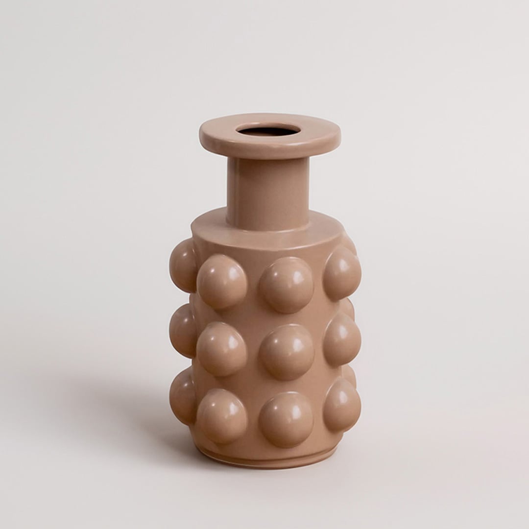 A beige contemporary vase featuring raised circular forms presented on a simple white background offering a clean minimal decorative look.