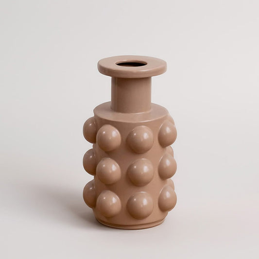 A beige contemporary vase featuring raised circular forms presented on a simple white background offering a clean minimal decorative look.