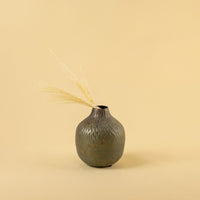 Brown hammered metal vase decor styled in a warm modern room adding rustic charm to living room shelves consoles and tables.