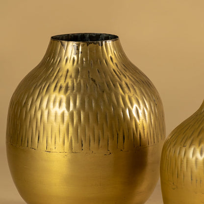 Gold hammered metal vase closeup showing textured finish perfect for modern decor on tables shelves and living spaces.