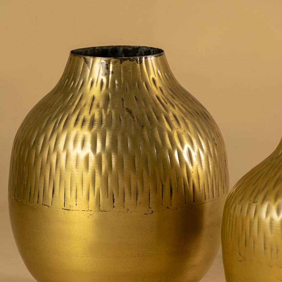 Gold hammered metal vase closeup showing textured finish perfect for modern decor on tables shelves and living spaces.