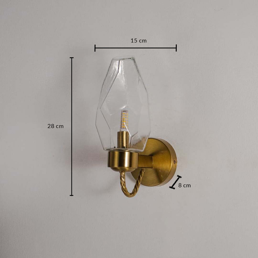 Wall lamp with geometric clear glass shade and gold finish base shown with size 28 cm height 15 cm width and 8 cm depth.