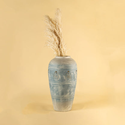 Tall blue carved terracotta vase styled in a warm interior adding handcrafted charm and elegant detailing to modern natural home decor styling.