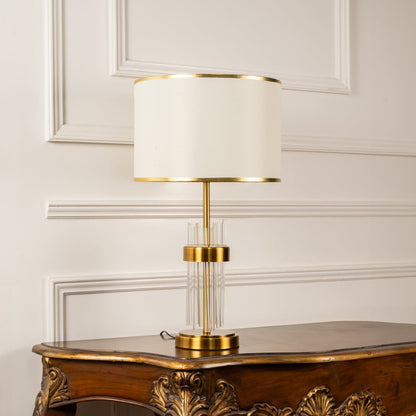 Lucent modern table lamp with gold and crystal base styled on wooden console for elegant living room lighting ambience.