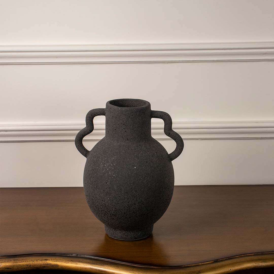 Side angle view of black ceramic vase with unique dual handles and matte finish ideal for living room or hallway decor.