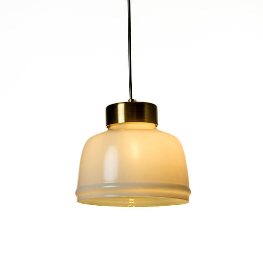 Illuminated cream glass pendant light with polished gold accents adding soft warmth indoors.