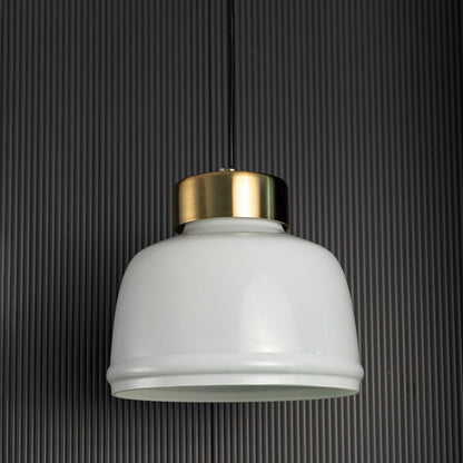 Frosted glass pendant light turned off with minimal white shade and brushed gold top displayed against black background.