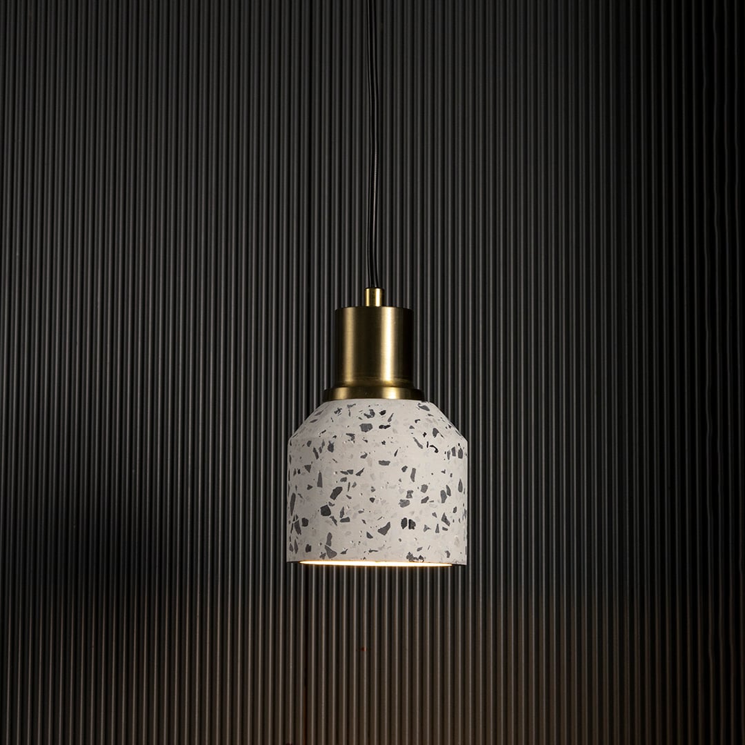 Terrazzo pendant light with warm glow highlighting brass and terrazzo texture for contemporary ceiling lighting.