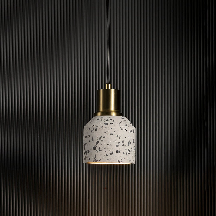 Terrazzo pendant light with warm glow highlighting brass and terrazzo texture for contemporary ceiling lighting.