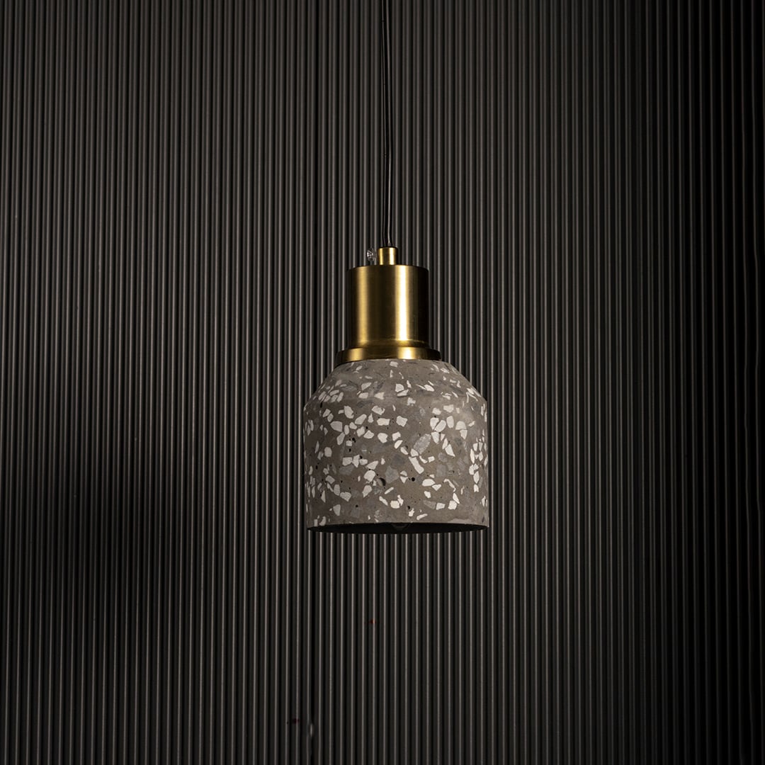 Pendant light with textured glass shade and gold metal holder displayed against dark background for dramatic decor lighting.