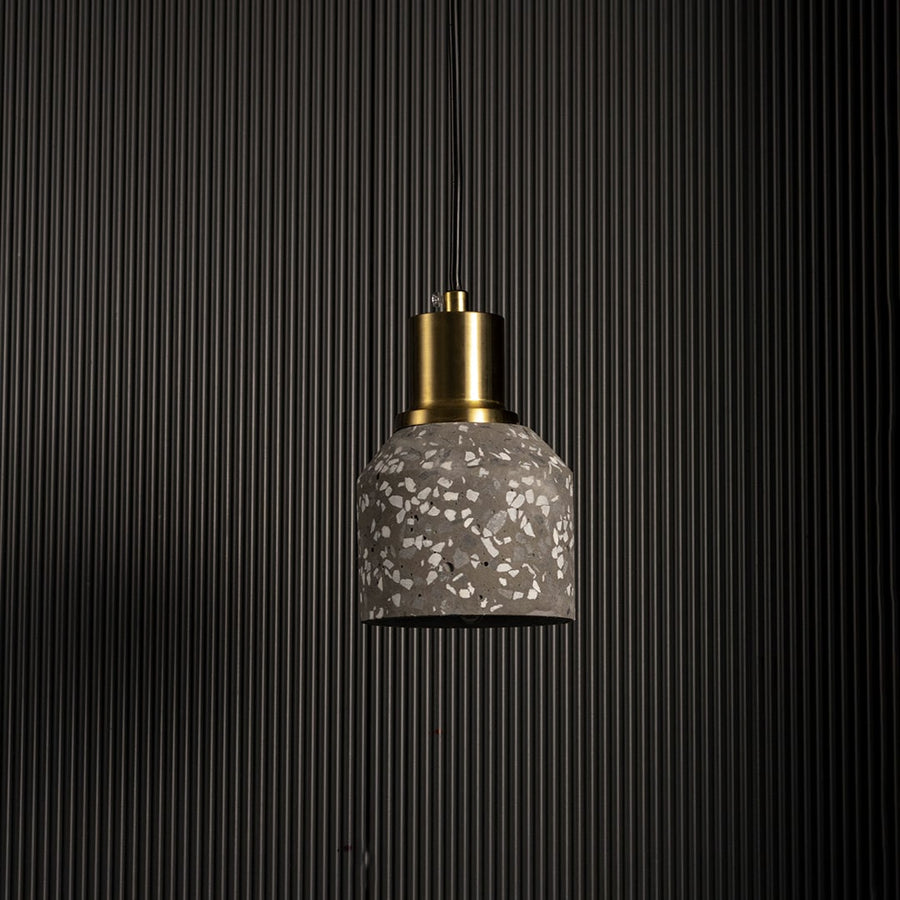 Pendant light with textured glass shade and gold metal holder displayed against dark background for dramatic decor lighting.