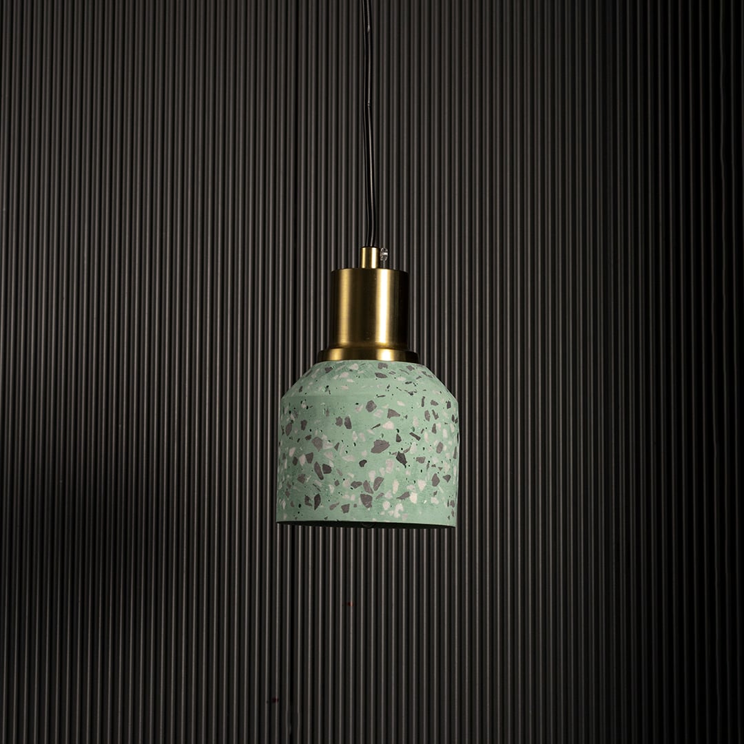 Green speckled ceramic pendant light with gold metal holder displayed unlit on dark background for modern ceiling lighting decor.