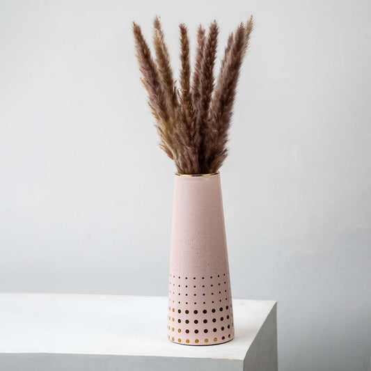 Small dried grass stems arranged in a tall pink vase perfect for earthy boho home décor and modern minimal natural interior styling.