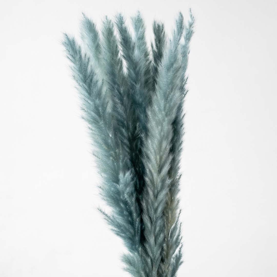 Detailed view of blue textured glass vase highlighting pampas stems and golden rim for decorative styling.