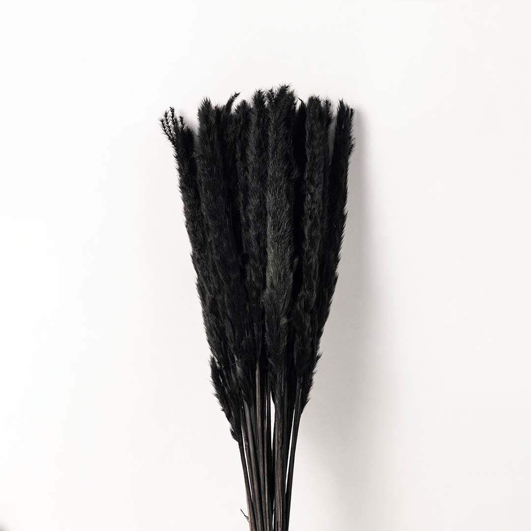 A closeup view of the textured ceramic vase showing the detailed pattern and black dried stems set against a white background highlighting the fine craftsmanship and contrast.