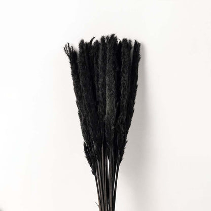 A closeup view of the textured ceramic vase showing the detailed pattern and black dried stems set against a white background highlighting the fine craftsmanship and contrast.