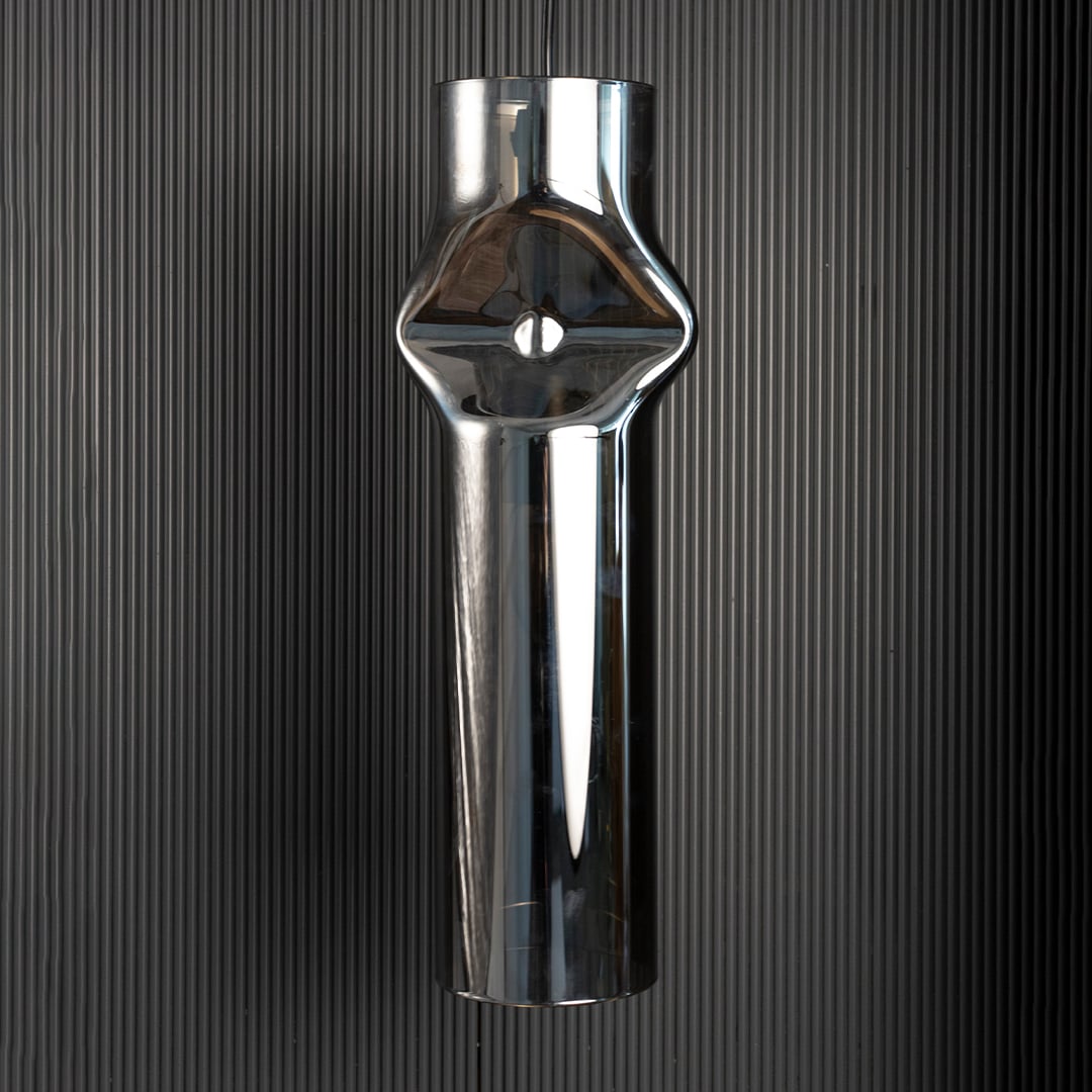Chrome pendant light turned off softly against dark background emphasizing its polished reflective metal surface.