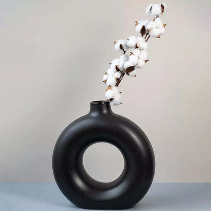 White cotton stem preserved natural flowers styled in modern black ceramic vase lifestyle home decor display.