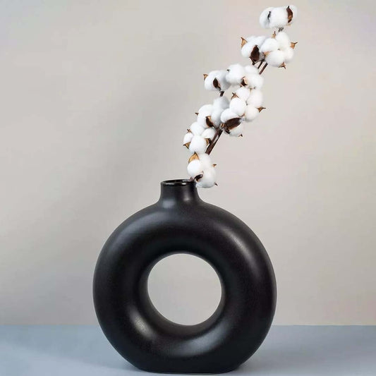 White cotton stem preserved natural flowers styled in modern black ceramic vase lifestyle home decor display.