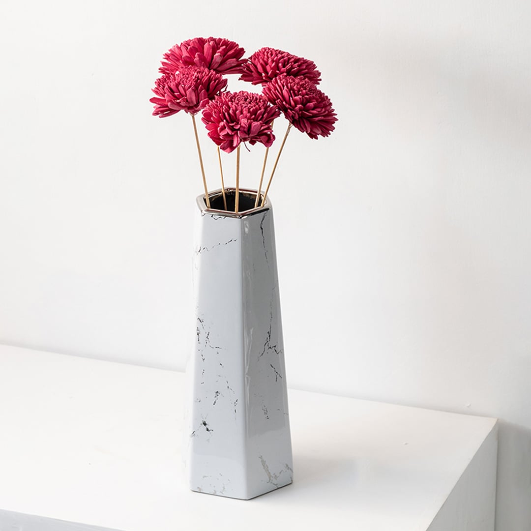 Pink sola flower sticks in a tall marble effect vase with artificial decorative flowers for home office and event decor.