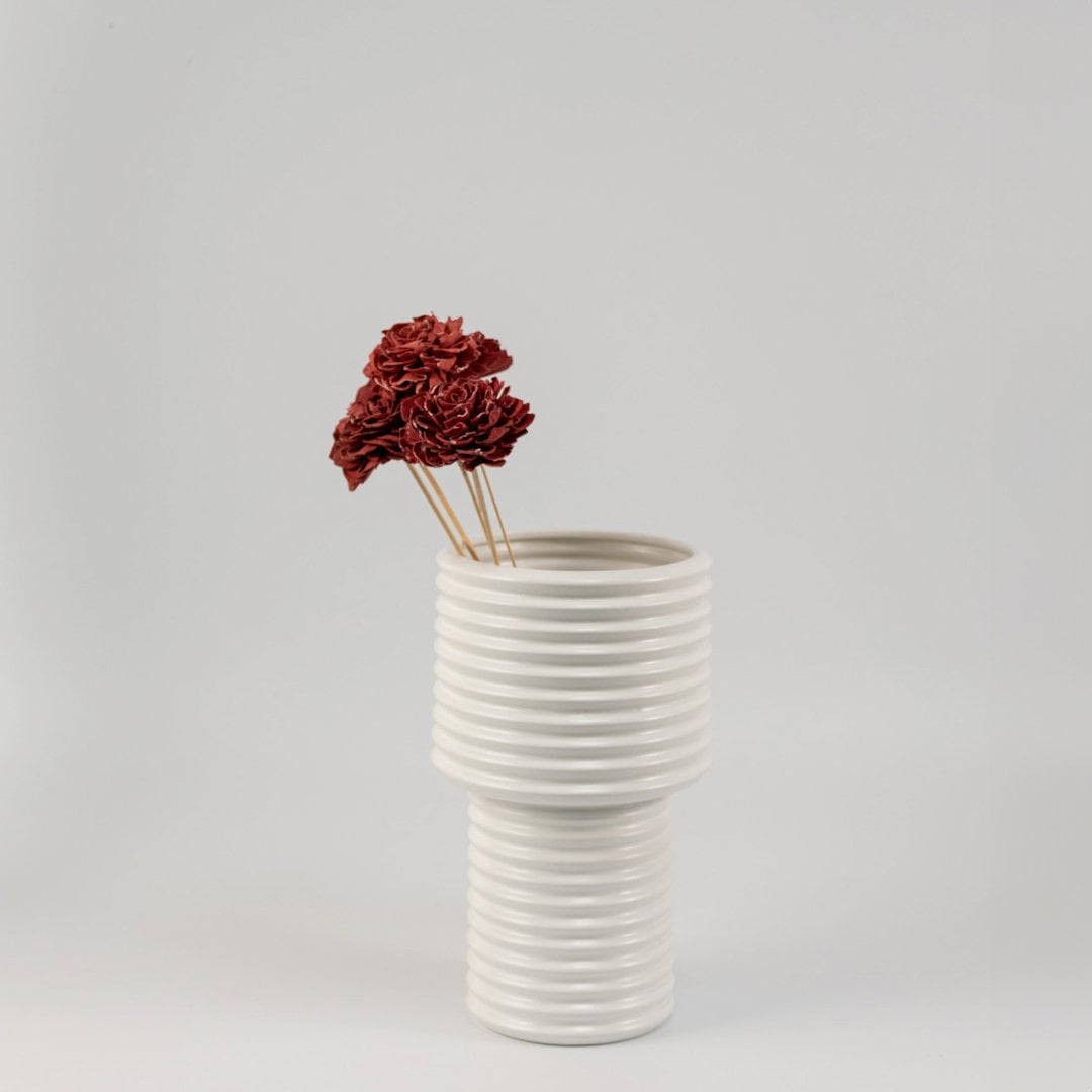 Red sola flower sticks arranged in a modern ceramic vase with artificial decorative flowers for stylish home and office decor.