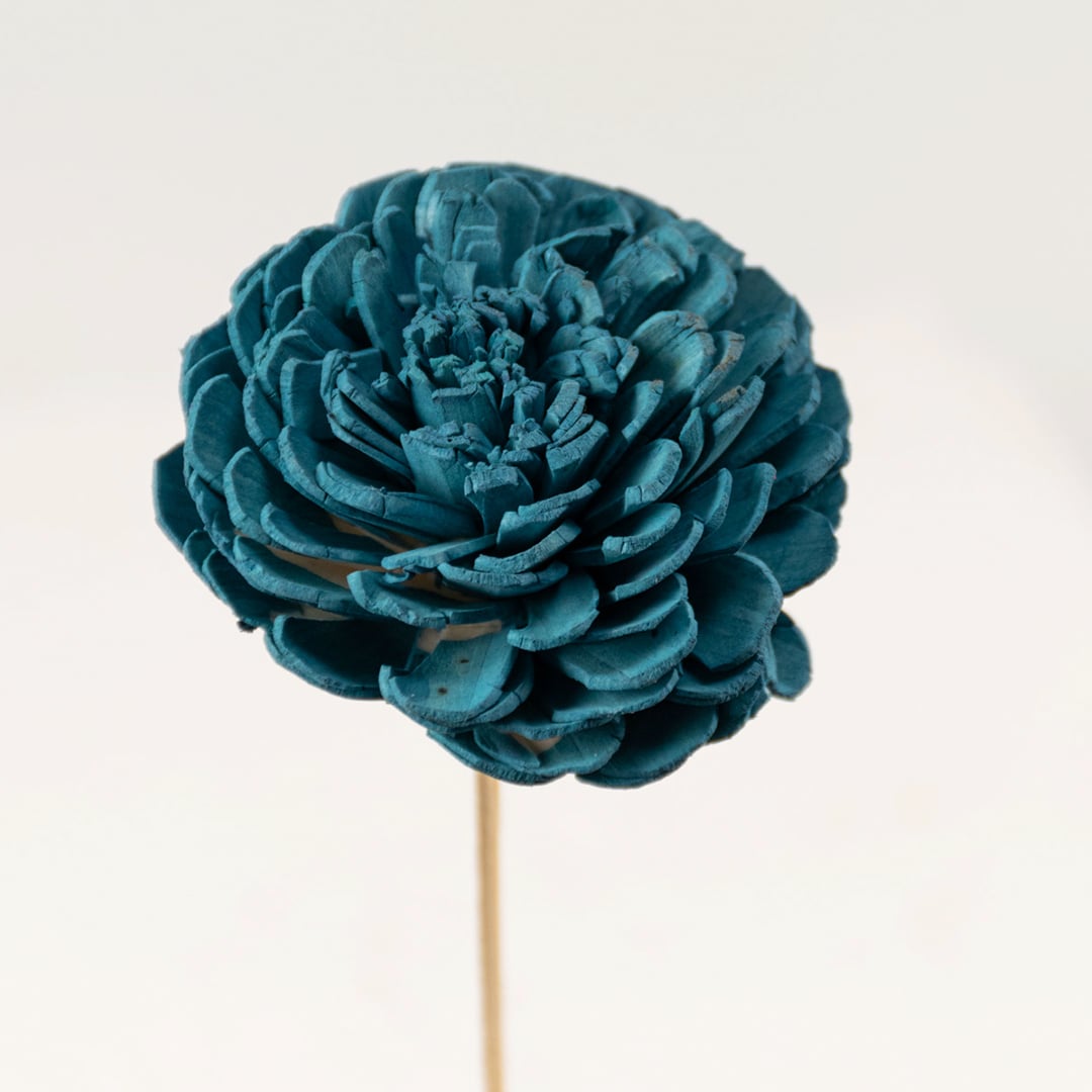 Closeup view of blue artificial flowers in glass vase showing petal texture and vibrant color for interior decoration.
