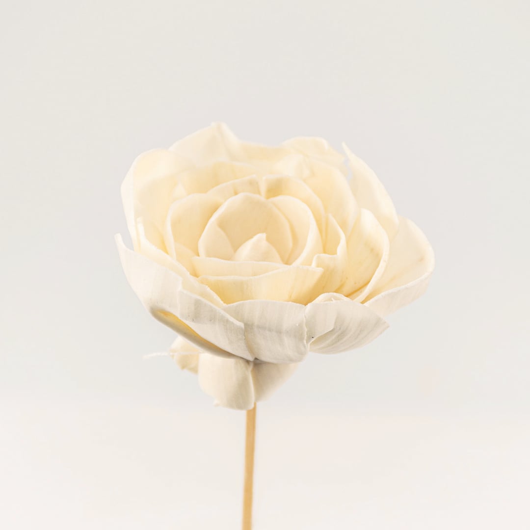 Detailed closeup of a white flower stick showing intricate petal layers and natural finish.