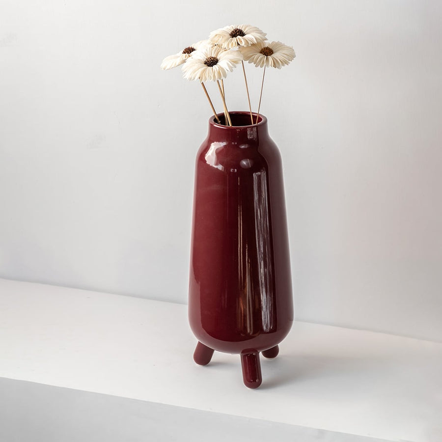 Elegant ceramic vase with flowers in a modern minimalist home decor setting – burgundy decorative vase for interiors.