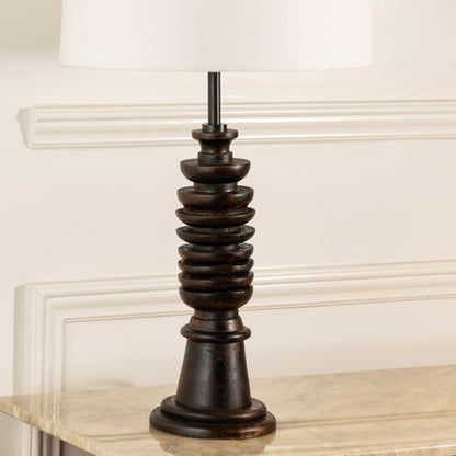 Turned wood lamp base with rich dark finish and bronze accents showcasing classic craftsmanship and decorative appeal.