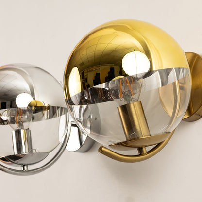 A closeup view of wall lights made from glass and metal featuring gold and chrome shades creating reflective highlights and stylish décor without lit.