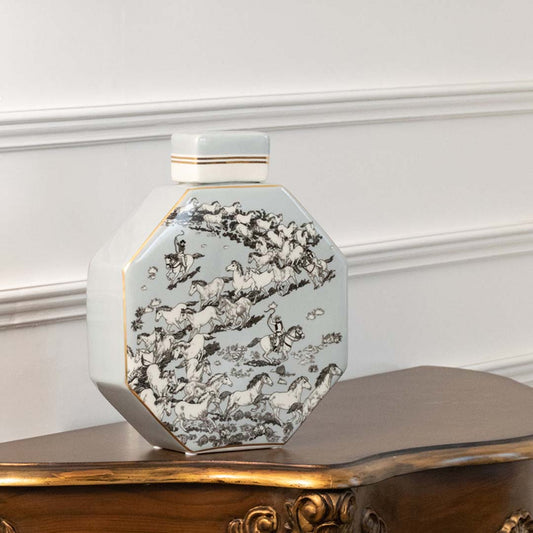 White ceramic decorative jar with black floral pattern displayed on a console table for modern home decor styling.