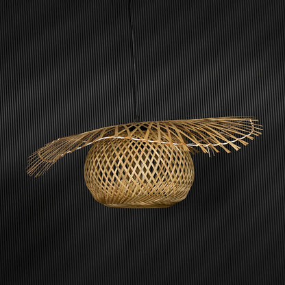 Rattan pendant light with wide handwoven bamboo shade in natural finish turned off against black background.