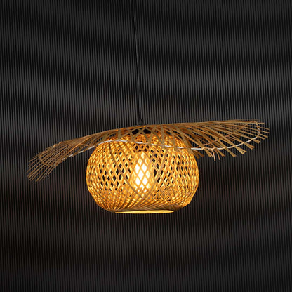 Wide rattan pendant light with handwoven bamboo shade turned on glowing softly against black background