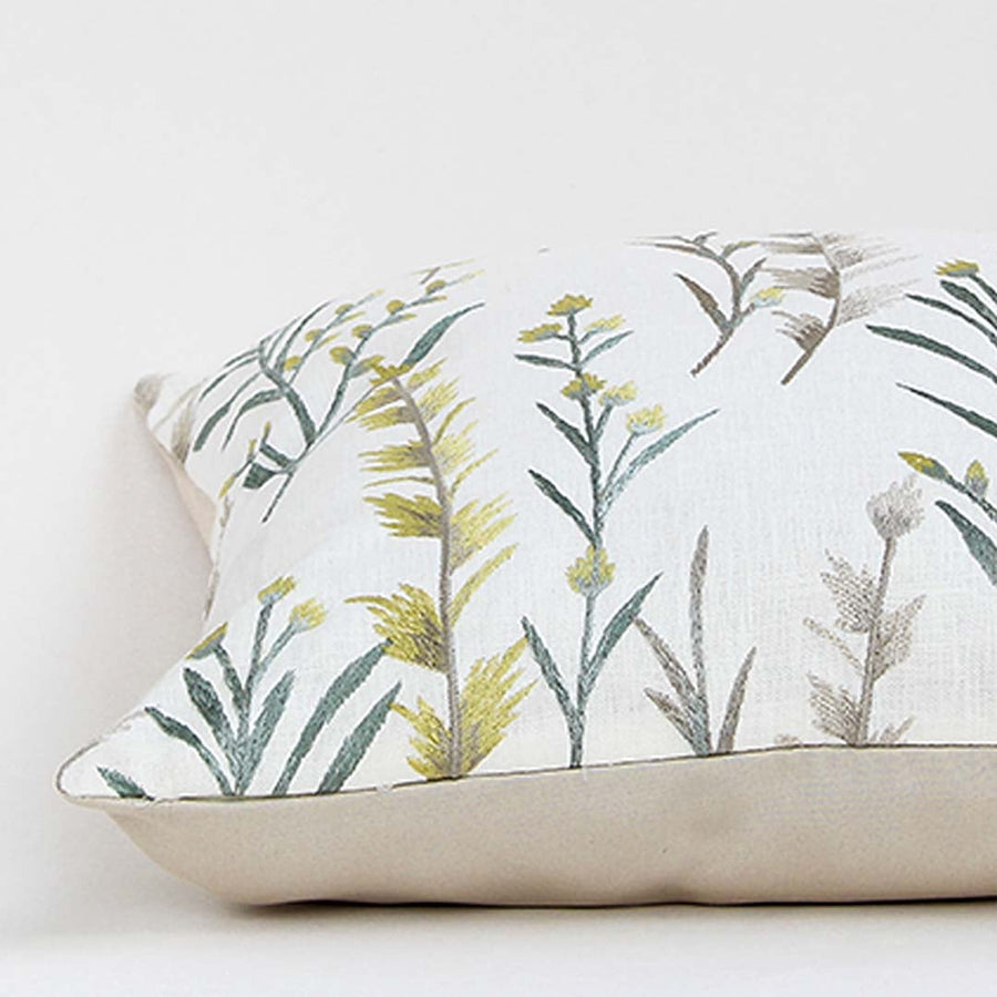Soft cotton cushion cover with green floral embroidery shown at an angle offering a calm nature inspired décor accent with a breathable gentle and skin friendly fabric suitable for modern home styling.