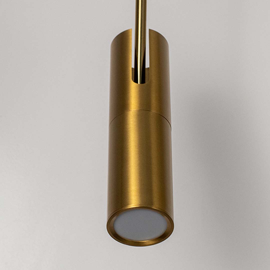 Closeup of modern gold cylindrical pendant light with metallic finish stylish ceiling lamp for luxury home interior lighting.