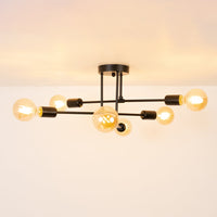 Black modern chandelier glowing warmly on white background showcasing sleek metal rods and round bulbs for elegant home lighting.