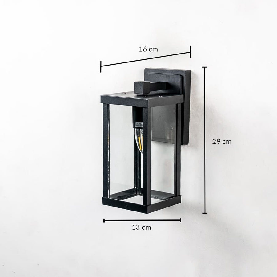 Outdoor wall light with black frame and glass shade shown with 29 cm height 16 cm width and 13 cm depth dimensions.