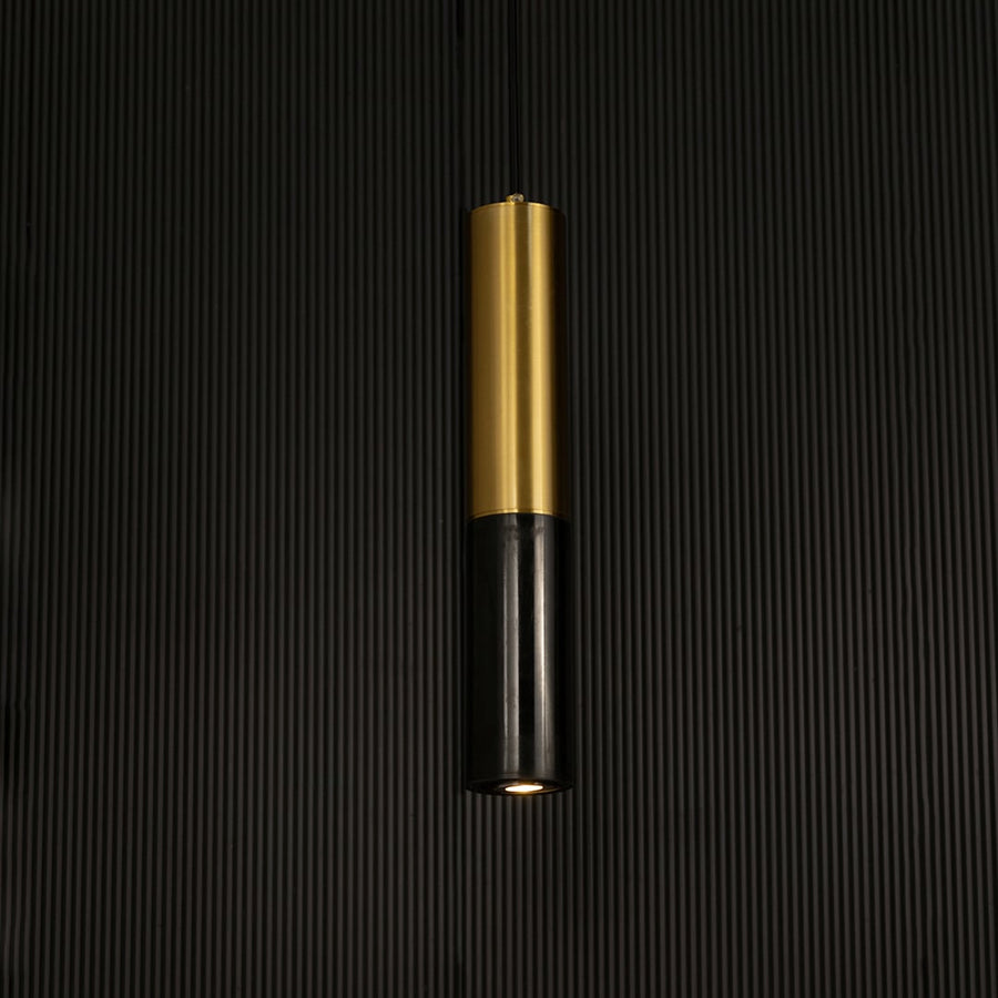 Black marble and metal cylinder pendant light hanging against dark textured wall with light off for bold modern décor.